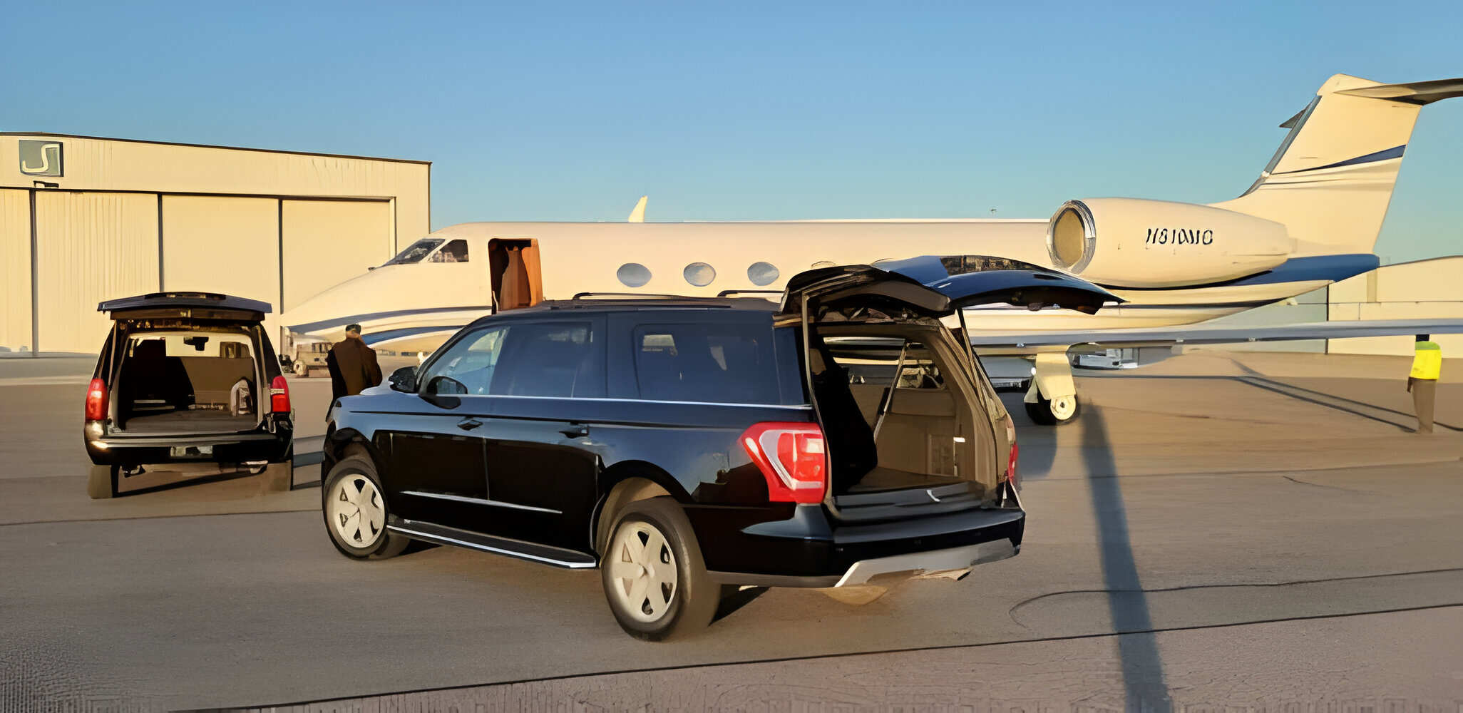 Luxury SUVs parked by a private jet