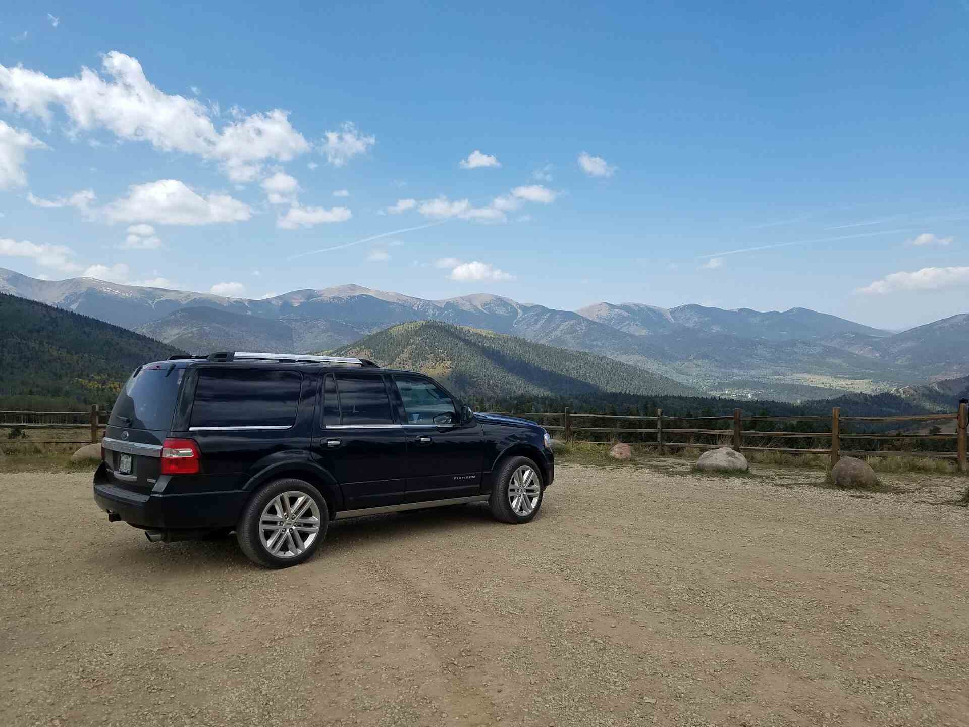 A Black SUV standing on a road side in mountains