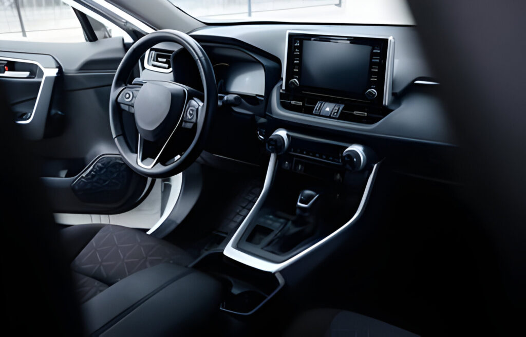 Modern black car interior, leather steering wheel, climate control, navigation, air ducts, deflectors on the car panel