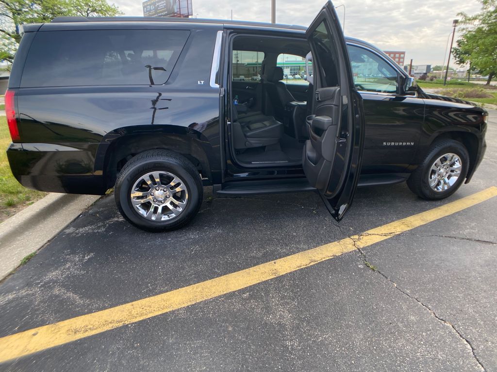 open door of a black SUV standing on a road