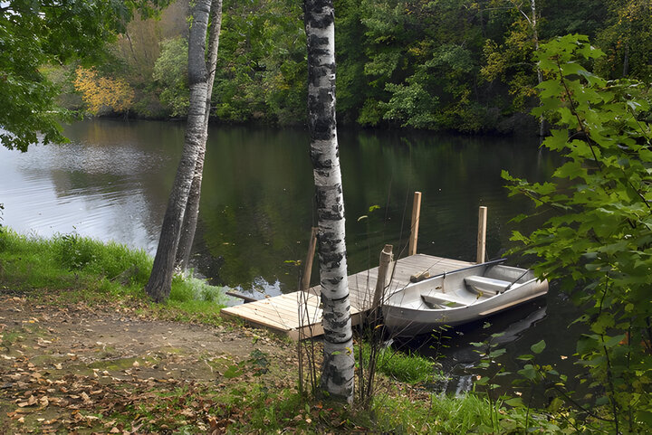 Autumn lake with a boat at a wooden pier in the foreground, Monroe County, Wisconsin