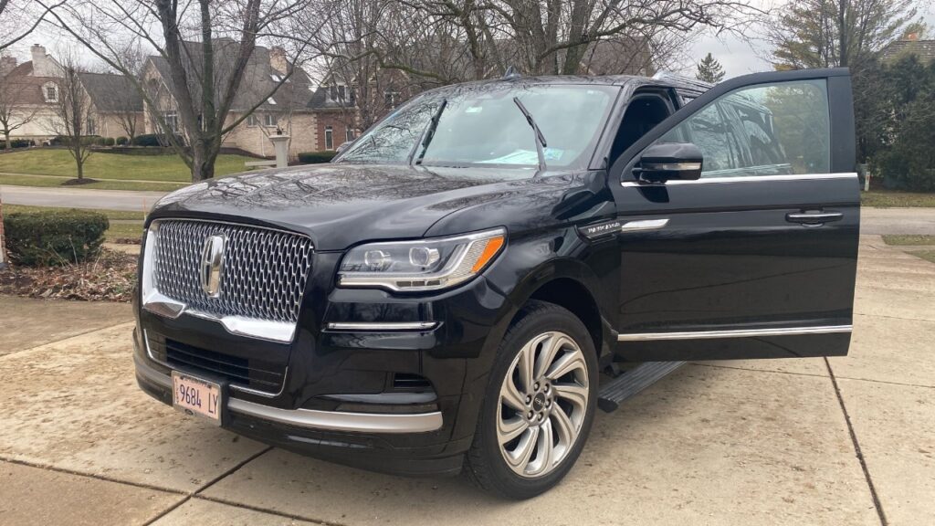 A black luxury SUV standing on a road and one door is opened