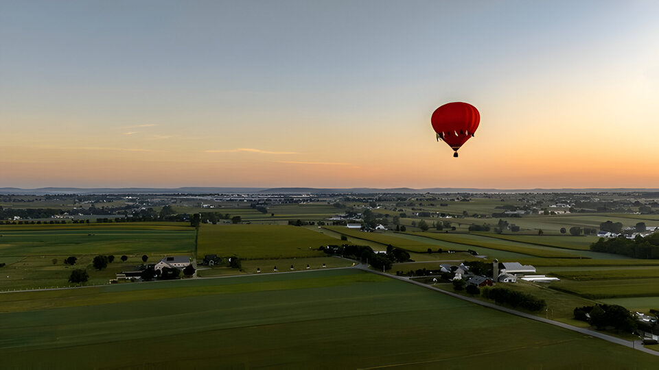 An Aerial View of a Red Hot Air Balloon, Floating Across Rural Pennsylvania, on a Sunny Morning