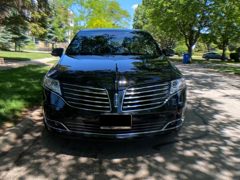 Luxury Black Car by Milwaukee Airport Town Car Service, Park on the road in a shiny day